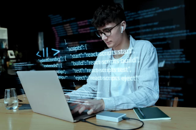A boy writing code on the laptop using AI Tools for Developers